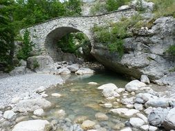 stone bridge over a mountain river in the Upper Alps