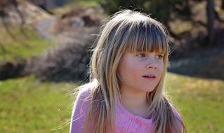 blond child face on the nature