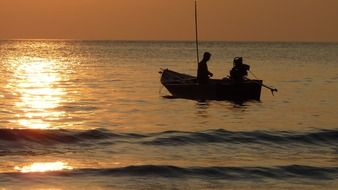 Fishermen on a boat at sunset