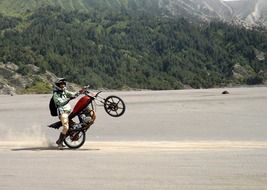 motorbiker jumping on sand at mountains, indonesia, east java