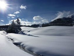 bright sun over a snowy landscape in switzerland