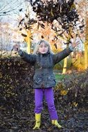 blonde girl playing leaves autumn