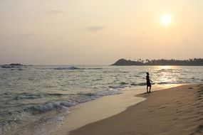 tourist on a tropical beach against the evening sun