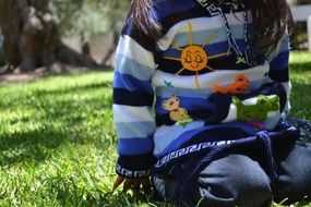 Child is sitting on the grass