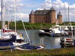 boats on lake in view of medieval castle Muiderslot, netherlands, muiden