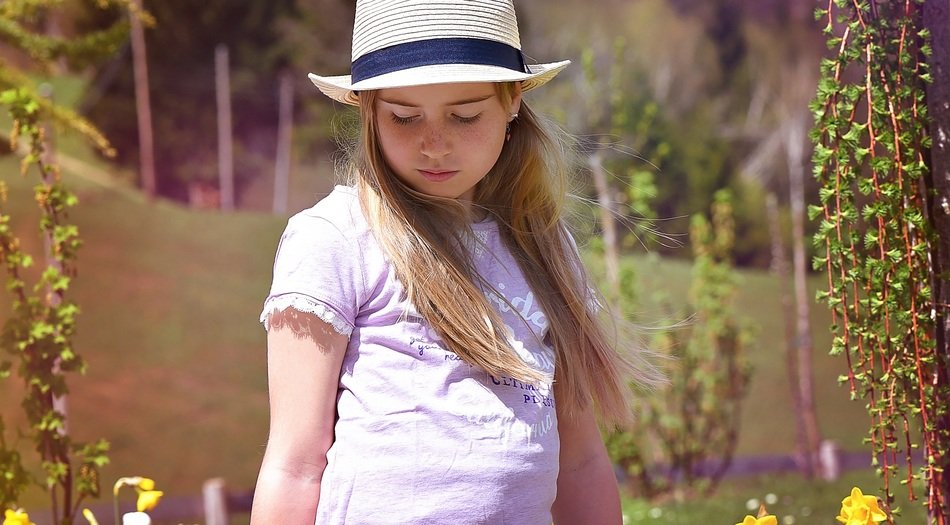 long haired child girl in hat looking down