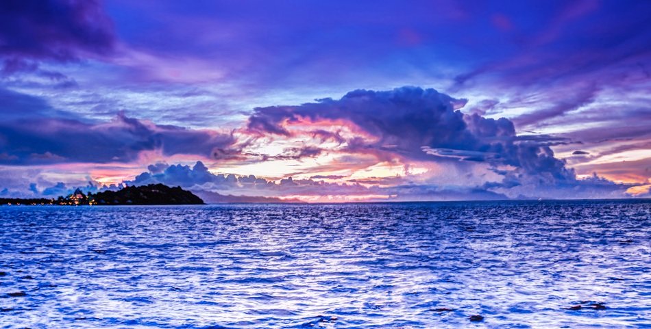 Beautiful view of the colorful sunset among clouds about the water