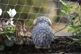 toy sheep in flowerbed