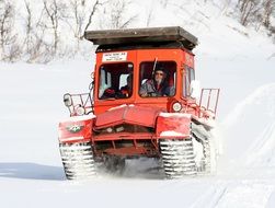 people in cabin of snowcat, fully tracked vehicle, speeding on snow
