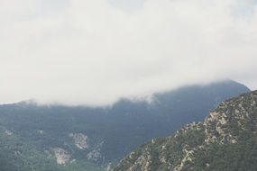 white clouds on grey mountains