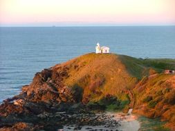 white lighthouse on a hill in autumn