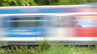 train at speed on the background of green trees