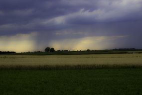 rain clouds landscape over green fields