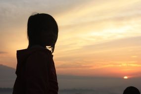 silhouette of a girl on a background of bright dawn