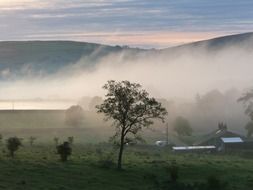 countryside landscape with mist and mountains