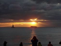 sailboat on the horizon of the sea during sunset