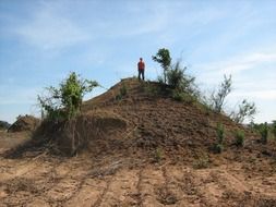 man on top of a giant anthill in africa