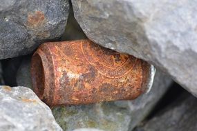 rusty tin between stones