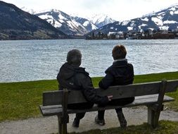 couple on a bench by a mountain lake