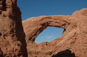 stone arch in the rocks on the background of blue sky