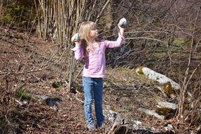 blonde girl with stones in hands