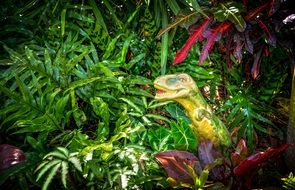 dinosaur garden statue in green plants
