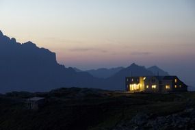 illuminated hut on top of the mountain at night