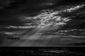 Black and white photo of cloudscape with the water in summer