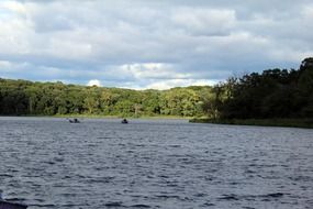 photo of boats on a forest lake