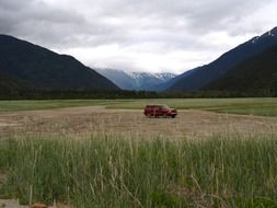 red car among the nature of alaska