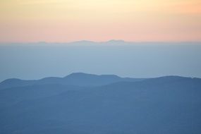outlines of the mountains in the early foggy morning