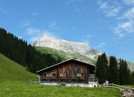 wooden cottage on the background of the Arlberg mountain range