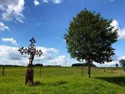 Metallic cross near a tree in France