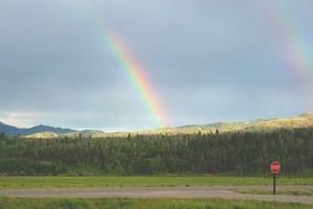 double rainbow above mountains in wilderness