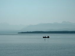 Beautiful scenic landscape with the boat in the lake and the mountains