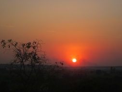 distant view of the orange sun in the evening sky