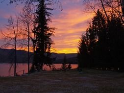 Colorful sunset on landscape with trees and water