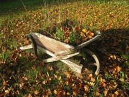 old wooden car on a lawn with autumn leaves