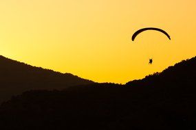 paragliding, black silhouette at yellow sky