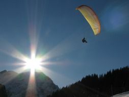 Paraglider in the mountains of the Arlberg in the bright sun