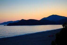empty beach chairs in the evening at colorful sunset on horizon