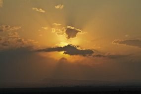 setting sun covered by a cloud