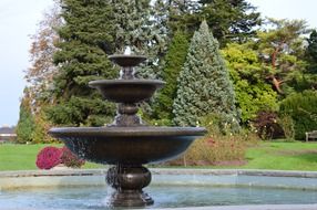 cascading fountain in park garden trees