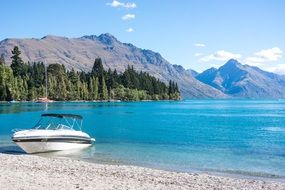 motor boat on seashore at mountain landscape, new zealand, queenstown