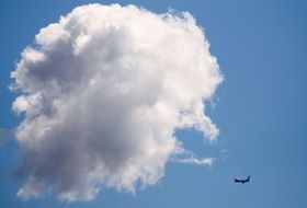 aircraft in sky near fluffy cloud