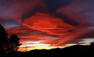 dramatic sunset above dark mountains