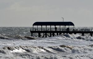 stormy waves of the ocean on the background of the pier