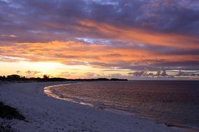 Beautiful and colorful sunset in clouds above the beautiful sandy beach