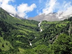 Mountains with a waterfall and green trees