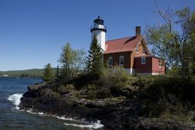 small lighthouse on a forest rock